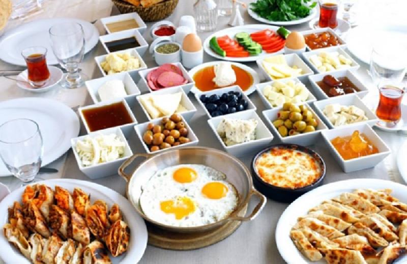 Bol çeşidli səhər yeməyi dəsti isti yemək və samovar çayı daxil