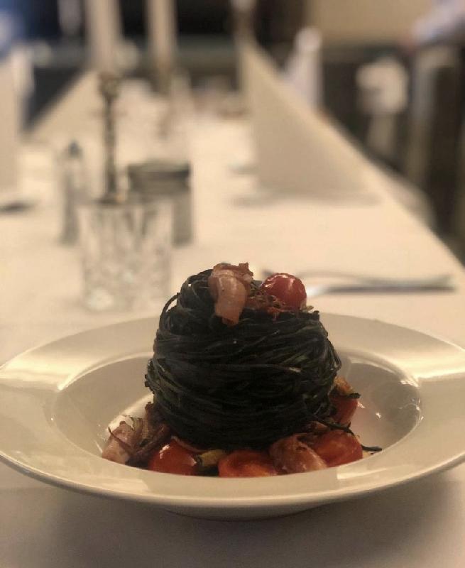 Tagliolini al nero di seppia aglio, olio datterini e salmone